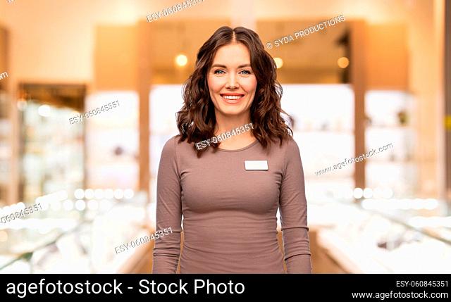 happy female jewelry shop assistant with name tag