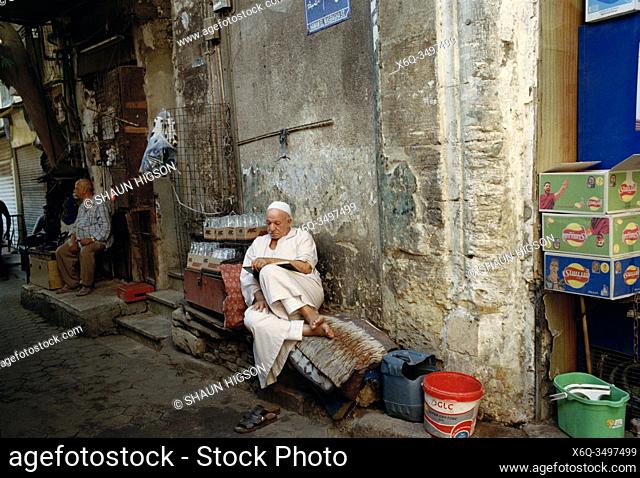 Egyptian man reading in the alleyways of Islamic Cairo in the city of Cairo in Egypt in North Africa
