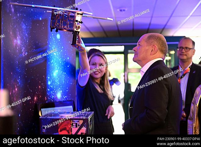01 September 2023, North Rhine-Westphalia, Cologne: German Chancellor Olaf Scholz (SPD) looks at a model of the MASCOT lander (Mobile Asteroid Surface Scout)...