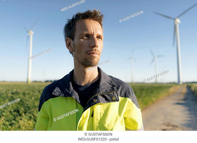 Portrait of an engineer on field path at a wind farm