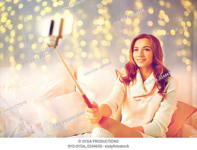 happy woman taking selfie by smartphone at home