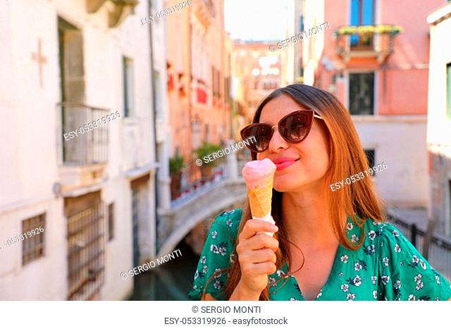 Beautiful happy girl with sunglasses eating ice cream in Venice, Italy