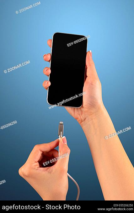 Close-up view of hand charging smartphone