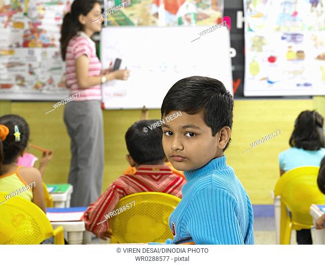 South Asian Indian boy looking behind in nursery school MR