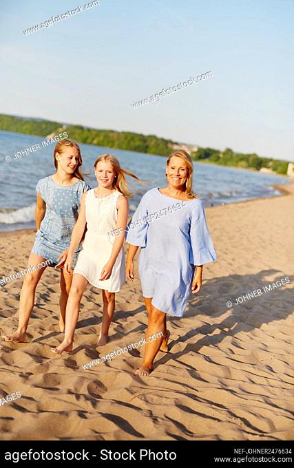 Mother with daughters walking on beach