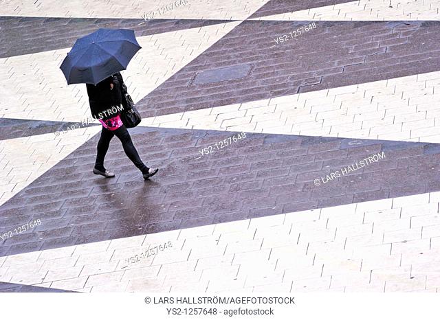 Woman with umbrella at Sergels Torg in the center of Stockholm, Sweden, Europe