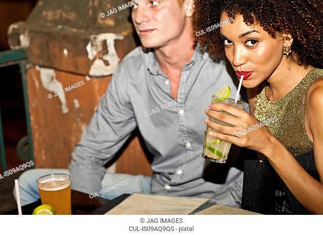 Couple sitting together in bar, drinking