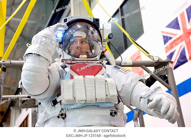 NASA astronaut Michael Hopkins, Expedition 3738 flight engineer, makes final touches on a training version of his Extravehicular Mobility Unit (EMU) spacesuit...