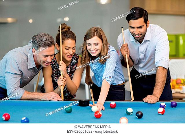 Smiling business colleagues playing pool