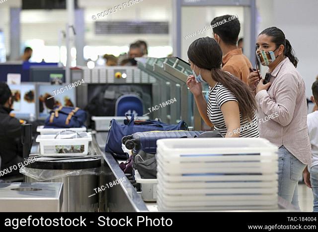 CANCUN, MEXICO - NOVEMBER 19: A person wears protective mask during the baggage check before board the plane at Cancun International Airport on November 19