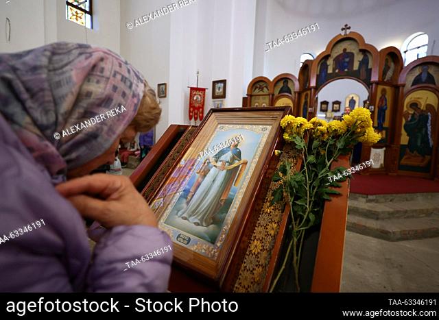 RUSSIA, LUGANSK - OCTOBER 14, 2023: A woman crosses herself during a service at the Church of Our Lady of Tenderness to mark the Christian feast of the...