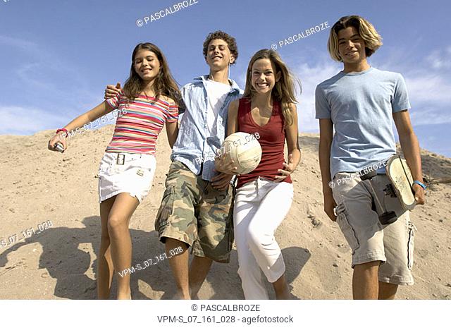 Low angle view of two teenage couples on the beach