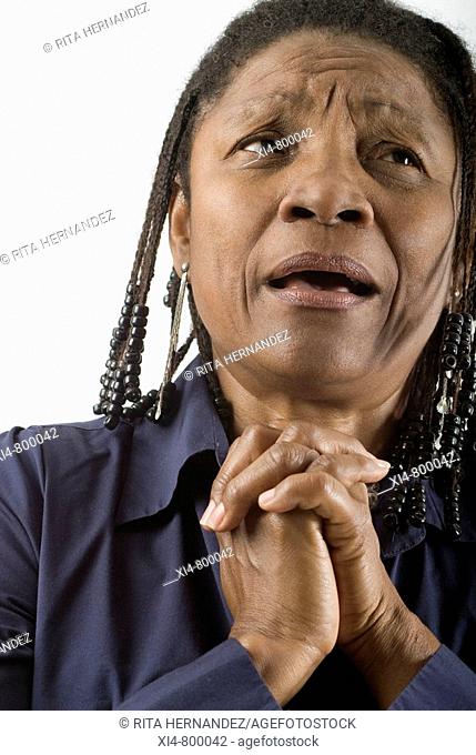 Close up of mature African hispanic woman, with crossed hands near her face