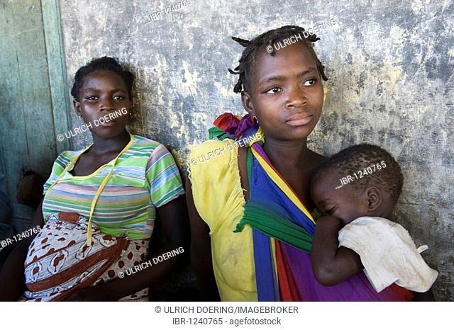 A woman carrying a child attends a HIV AIDS awareness campaign, Quelimane, Mozambique, Africa