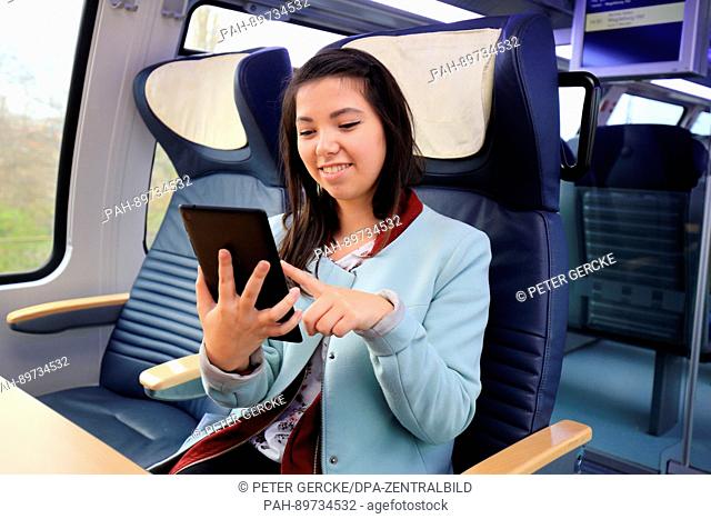 A young woman surfs the internet on her smartphone on a regional train on the line between Magdeburg and Schoenebeck, Germany, 5 April 2017