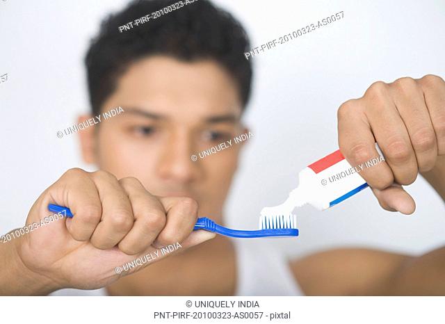 Man applying toothpaste on a toothbrush