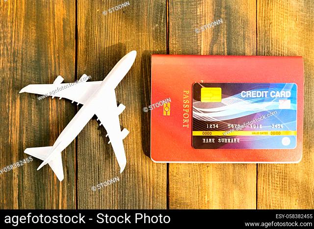 Credit card put on passport and airplane model on wooden table , Preparation for Traveling concept