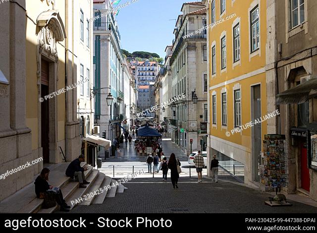 PRODUCTION - 05 April 2023, Portugal, Lissabon: The street ""Rua da Vitoria"" in Lisbon's old town with the church ""Igreja de Nossa Senhora da Vitoria"" (l)