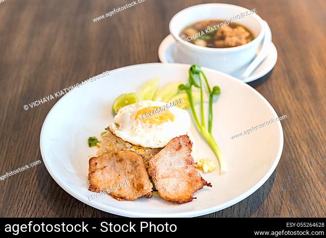 Fried rice with grilled pork and fried egg served with bak kut teh soup