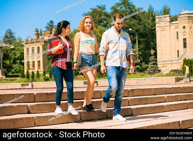 Positive students walking down the stairs. Students going down the stairs. Between lectures on campus