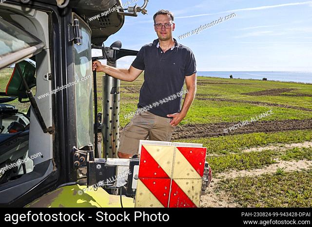 24 August 2023, Schleswig-Holstein, Burg (fehmarn): Carsten Marquardt is standing on a tractor. The 40-year-old farmer from Avendorf has joined the protest...
