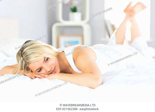 Smiling relaxed young woman lying in bed