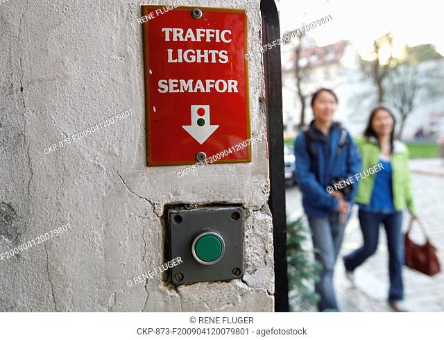 Tourists pass by a button opperating trafic lights on the Prague's narrowest street on Sunday, April 12, 2009 The street is fewer than 50 centimetres wide and...