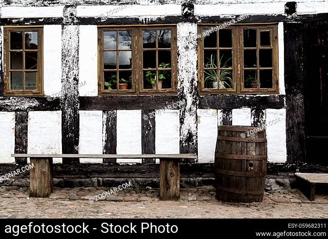White timbered house, with a bench and rainbarrel in the old town Den Gamle By in Aarhus Denmark