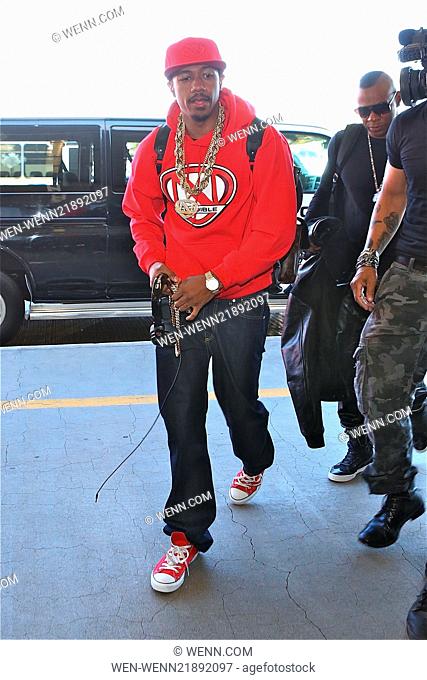 Nick Cannon departs from Los Angeles International Airport (LAX) wearing his N'Credible red hoodie and laden with gold chain necklaces