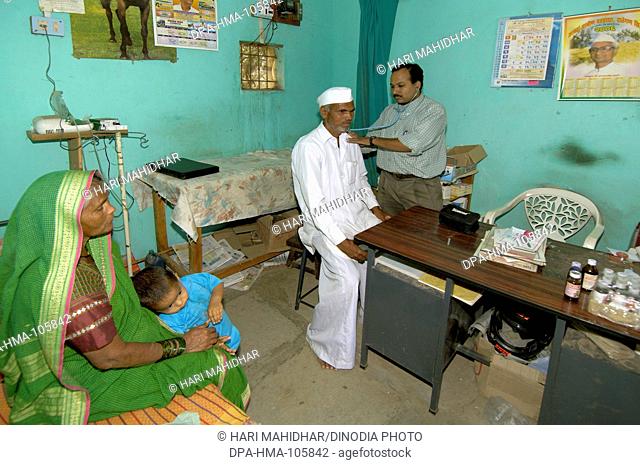 Doctor examining villagers at private clinic at Ralegan Siddhi near Pune ; Maharashtra ; India