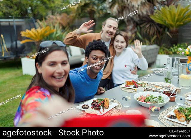 Happy couples taking selfie at patio lunch table