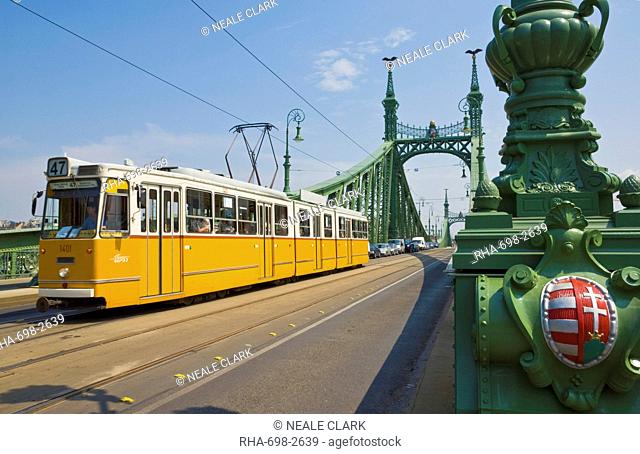 Yellow tram on The Liberty Bridge Szabadsag hid, over the Rver Danube, Vamhaz Korut street, Budapest, Hungary, Europe