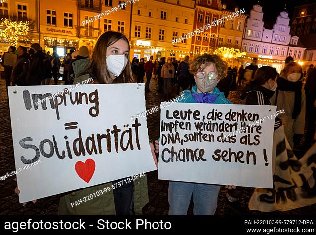 03 January 2022, Mecklenburg-Western Pomerania, Greifswald: A demonstrator shows a poster with the writing ""Vaccination = Solidarity""