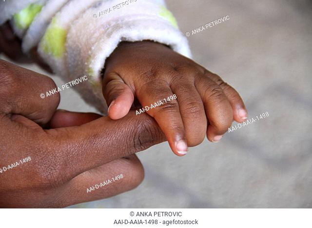 African Baby's left hand holding mother's right index finger, Pretoria, South Africa. 2012/12/15