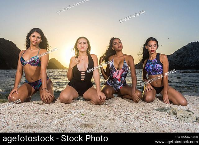 young sexy group women sitting on sand beach