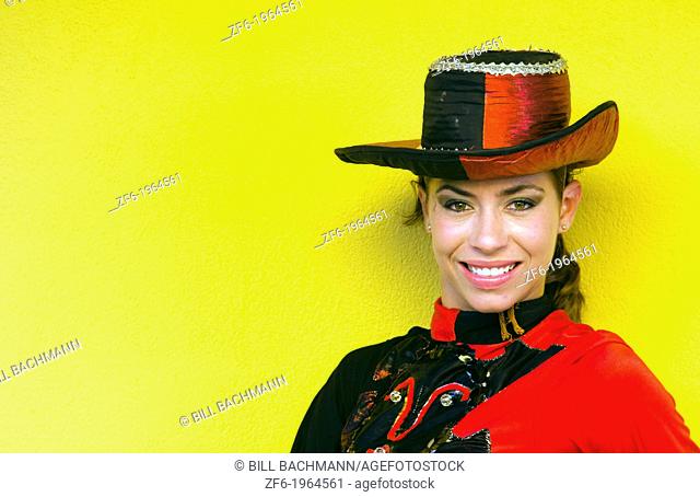 Trinidad Cuba dancer in costume and hat against yellow wall and smile