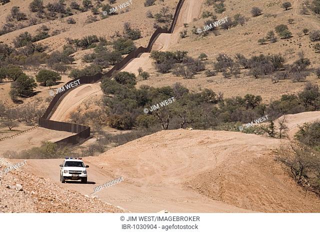 A US Border Patrol vehicle patrols the fence that separates the United States and Mexico in the Sonoran Desert west of Nogales, Nogales, Arizona, USA