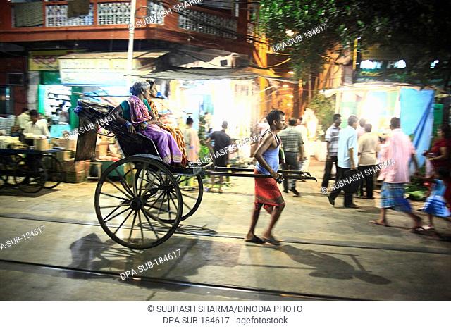 rickshaw puller transports passenger Durga Puja at Kolkatta India