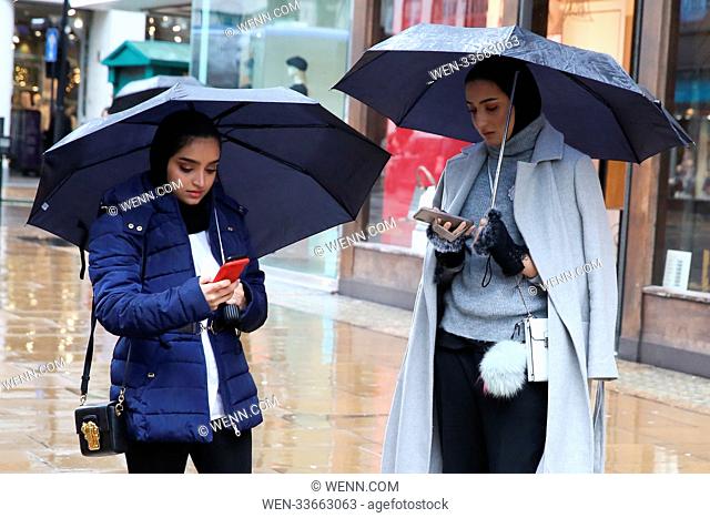 Shoppers shelter from the rain beneath umbrellas and under the hoods on Oxford Street Featuring: Atmosphere Where: London