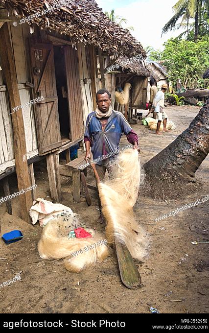 Antemoro ethnic fisherman repairing his fishing nets in Manakara