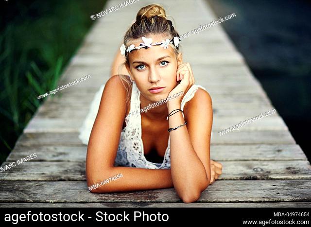 Young woman in white dress on a jetty