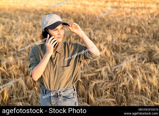 Woman on the phone standing in field