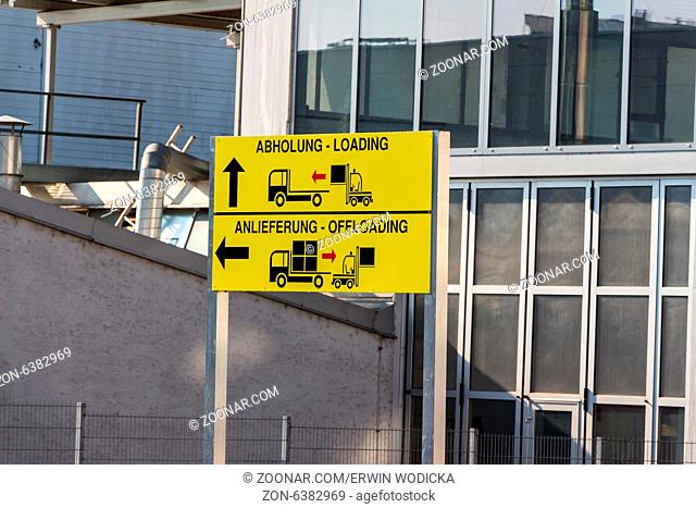 Ein Schild zeigt die unterschiedlichen Tore für Abholung und Anlieferung von Gütern mit LKWs an