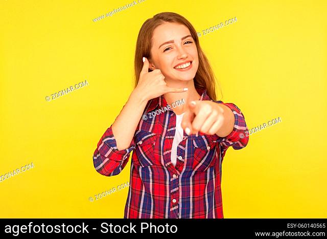 Hey you, call me back. Portrait of sweet lovely beautiful girl in shirt doing telephone gesture near ear and smiling, waiting for call, contact by phone