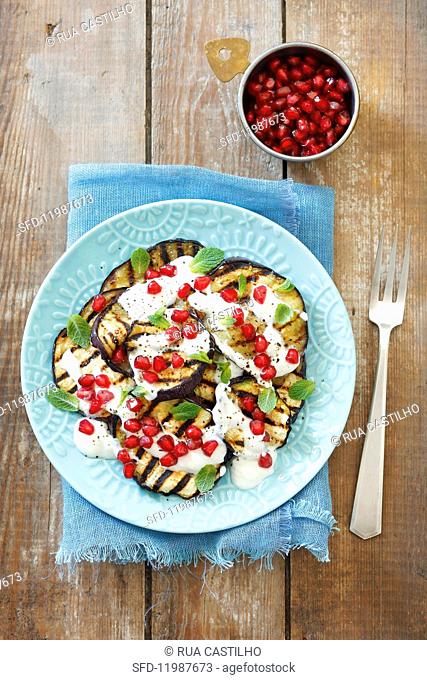 Grilled aubergine slices with yoghurt and pomegranate seeds