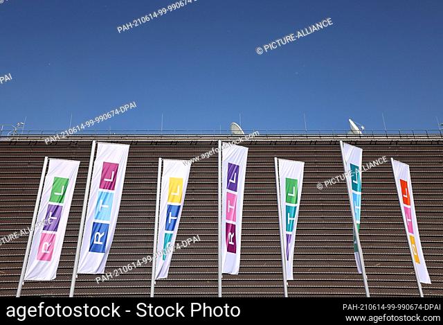 14 June 2021, North Rhine-Westphalia, Cologne: Flags with the new logo of the TV station RTL are flying in front of the building