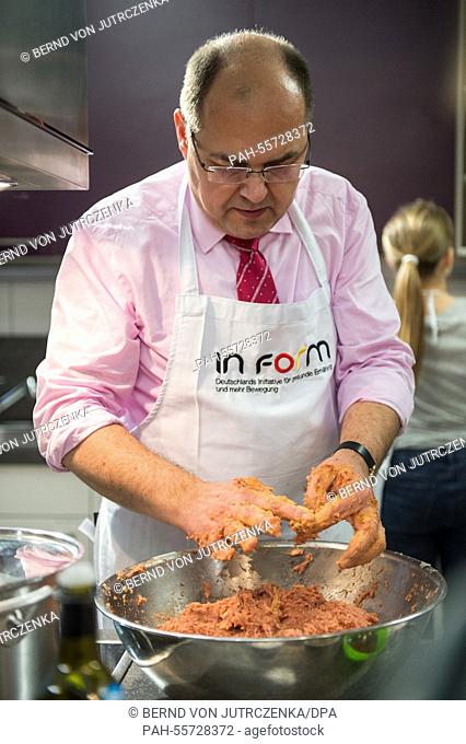 Christian Schmidt (CSU), Minister of Food and Agriculture cooks with pupils of the Schule Eins school in Berlin, Germany, 09 February 2015