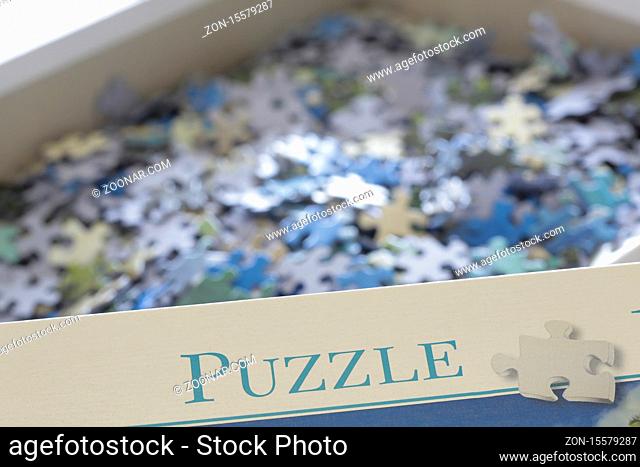 vorne Karton mit der Aufschrift Puzzle, hinten Haufen mit Puzzleteilen, Bergisches Land, NRW, Deutschland