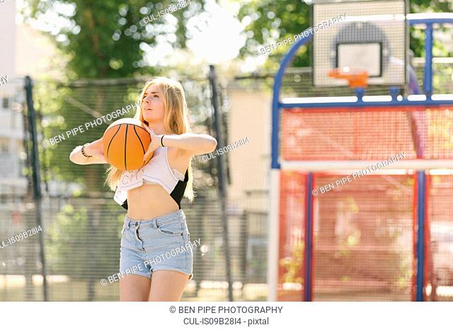 Young woman practising on basketball court