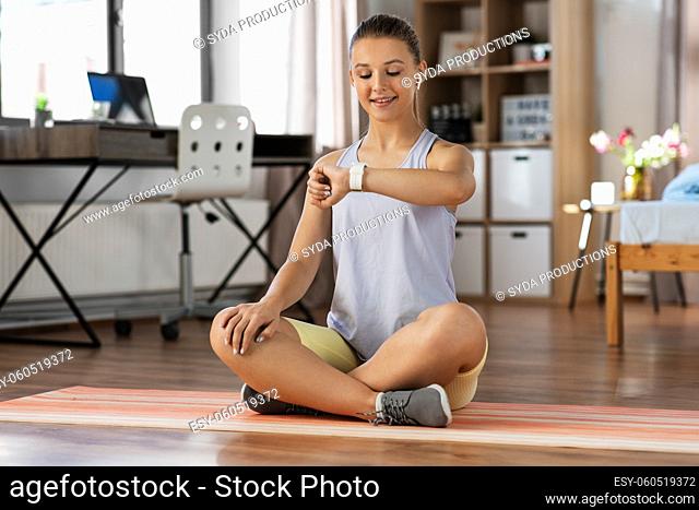 teenage girl with gadgets exercising at home